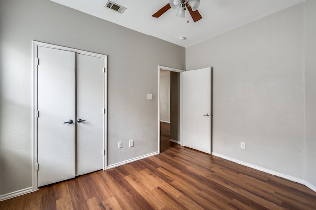 unfurnished bedroom with dark hardwood / wood-style flooring, ceiling fan, and a closet