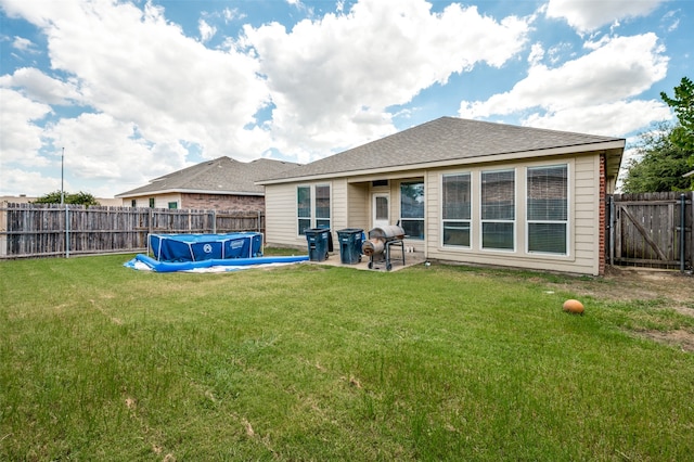 back of house with a yard, a patio area, and a swimming pool