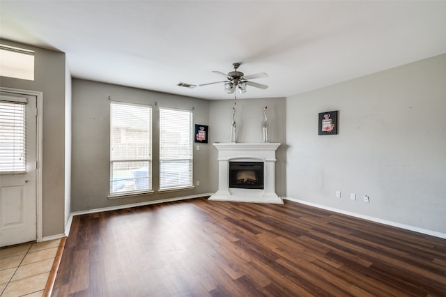 unfurnished living room featuring a healthy amount of sunlight, ceiling fan, and hardwood / wood-style flooring