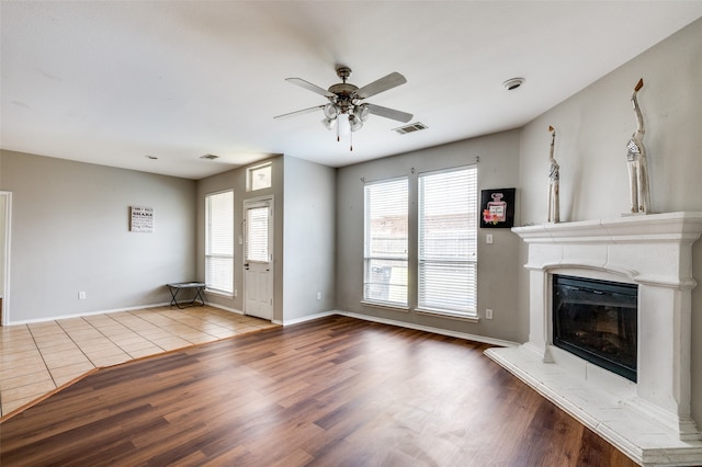 unfurnished living room with a healthy amount of sunlight, hardwood / wood-style floors, and ceiling fan