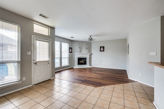 unfurnished living room with ceiling fan and light tile patterned flooring