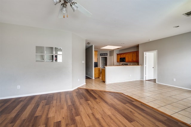 unfurnished living room featuring ceiling fan and light tile patterned flooring