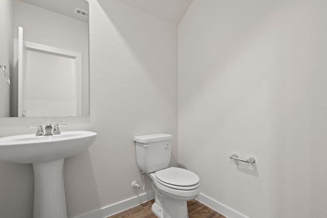 bathroom featuring sink, wood-type flooring, and toilet