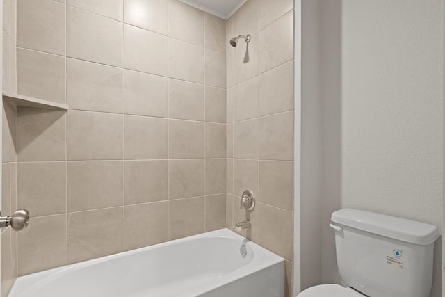 bathroom featuring tiled shower / bath and toilet