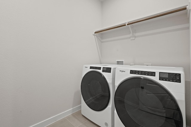 clothes washing area with separate washer and dryer and light tile patterned flooring