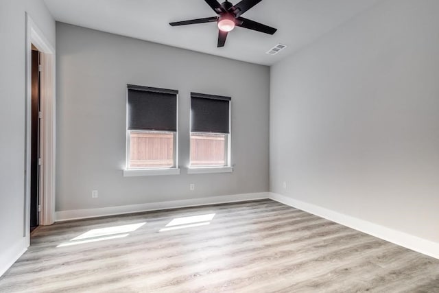 spare room with light wood-type flooring and ceiling fan