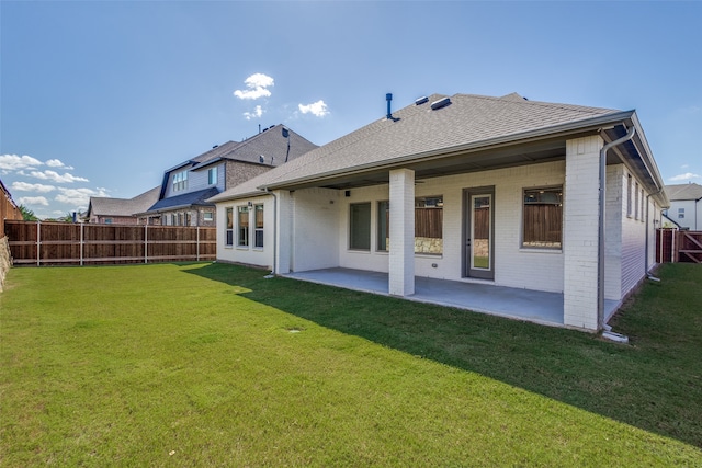 rear view of house featuring a yard and a patio