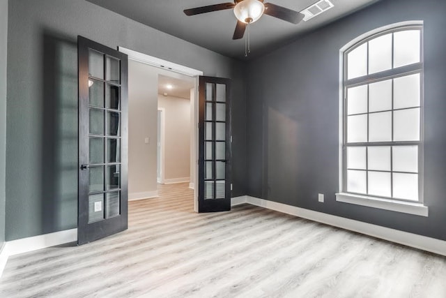 empty room with light hardwood / wood-style flooring, french doors, and ceiling fan