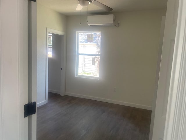 spare room featuring a wall mounted air conditioner, ceiling fan, and dark hardwood / wood-style flooring