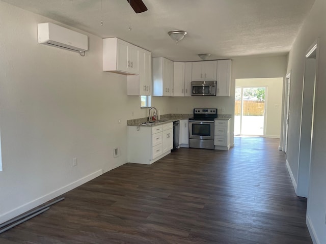 kitchen with ceiling fan, stainless steel appliances, white cabinetry, and dark hardwood / wood-style floors