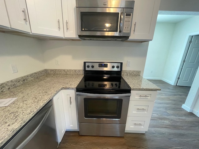 kitchen with appliances with stainless steel finishes, white cabinets, and light stone counters