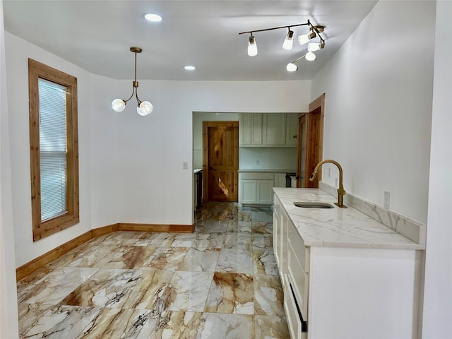 kitchen with pendant lighting, rail lighting, light tile patterned flooring, a notable chandelier, and sink