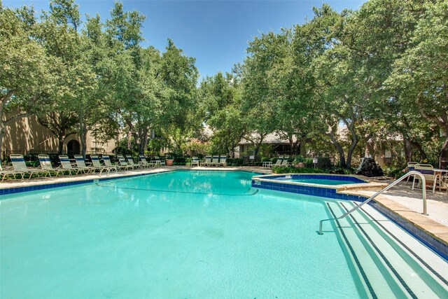 view of swimming pool featuring a hot tub