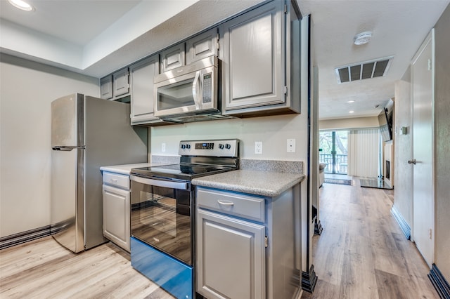 kitchen featuring light hardwood / wood-style flooring, gray cabinets, and stainless steel appliances