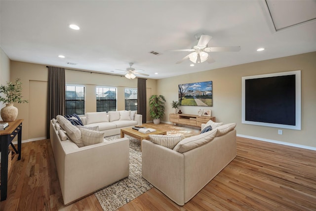 living room featuring ceiling fan and light hardwood / wood-style flooring