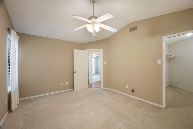 unfurnished bedroom featuring ceiling fan, light carpet, and vaulted ceiling