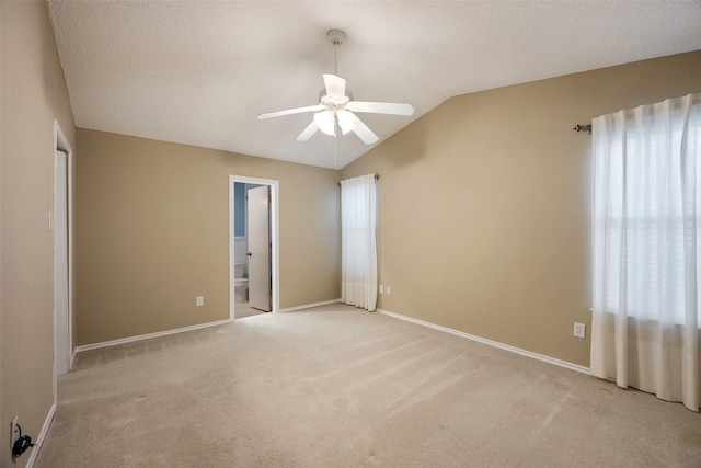 carpeted empty room with ceiling fan and lofted ceiling