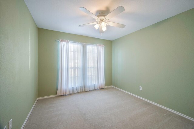 spare room featuring ceiling fan and light colored carpet