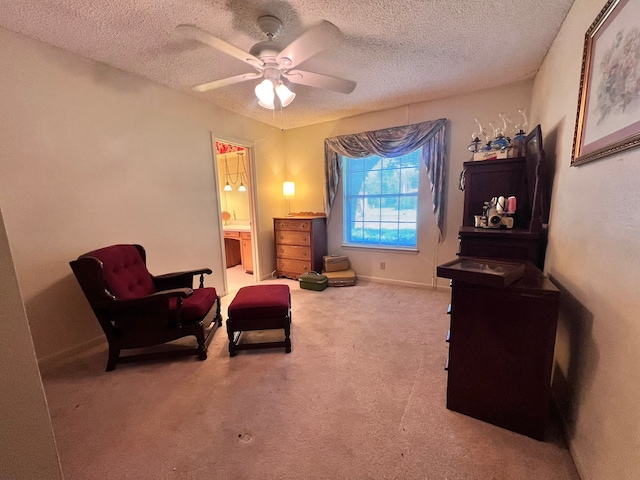 living area with ceiling fan, a textured ceiling, and carpet