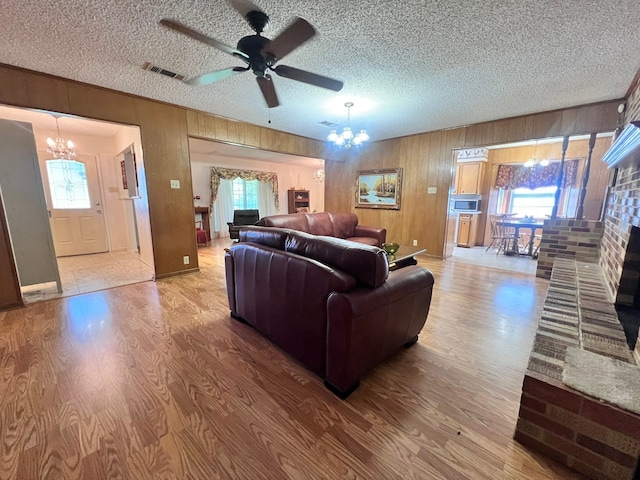 living room with hardwood / wood-style flooring, ceiling fan with notable chandelier, and plenty of natural light