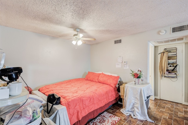 bedroom featuring ceiling fan and a textured ceiling