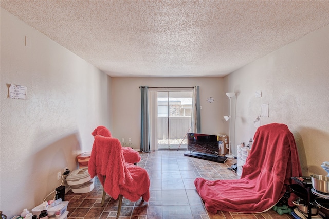 living area with tile patterned flooring and a textured ceiling