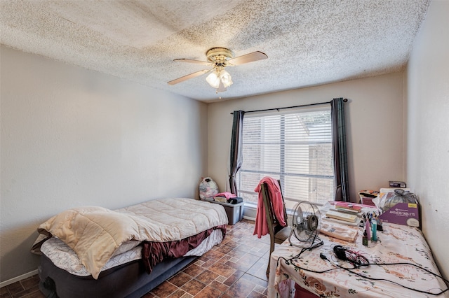 bedroom featuring ceiling fan and a textured ceiling