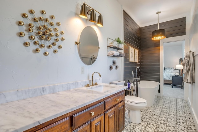 bathroom with tile patterned floors, vanity, toilet, and a tub