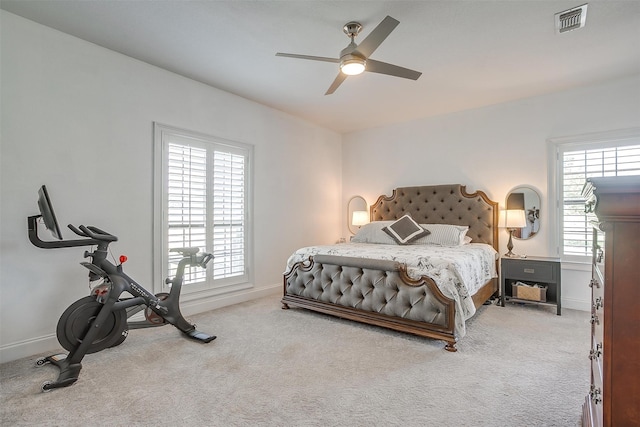 carpeted bedroom with ceiling fan and multiple windows