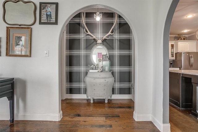 interior details with hardwood / wood-style flooring, stainless steel fridge, and crown molding