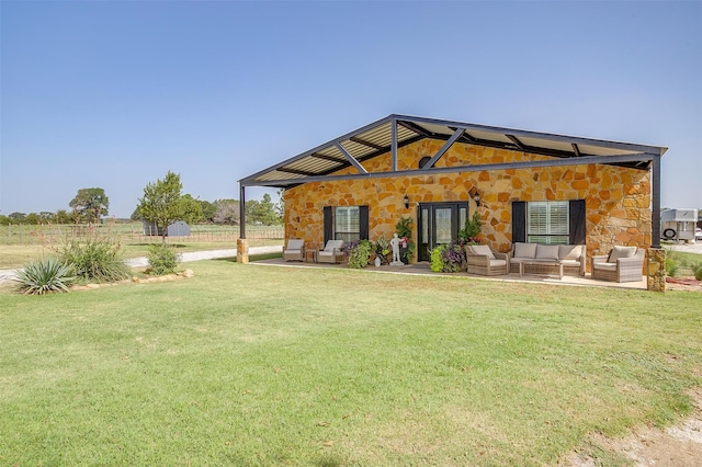 back of property with a yard and an outdoor living space