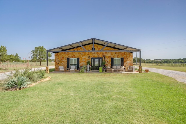 view of front of house with french doors, an outdoor living space, a rural view, a front yard, and a patio area