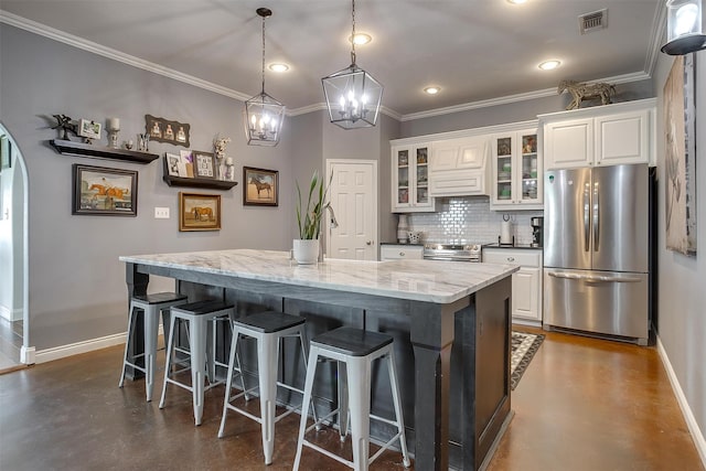 kitchen featuring light stone counters, stainless steel appliances, a spacious island, white cabinetry, and hanging light fixtures