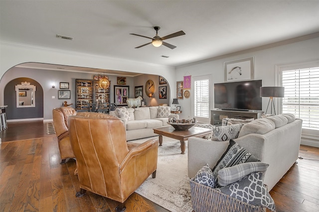 living room featuring a healthy amount of sunlight, dark hardwood / wood-style floors, and ornamental molding