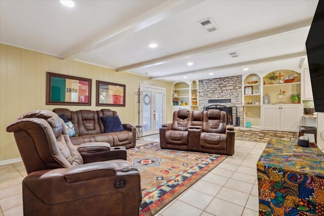 living room with a stone fireplace, french doors, light tile patterned flooring, built in shelves, and beamed ceiling