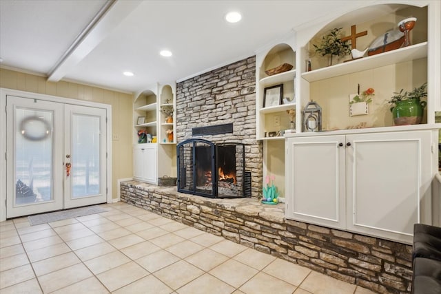 living room featuring beam ceiling, a fireplace, french doors, and light tile patterned floors