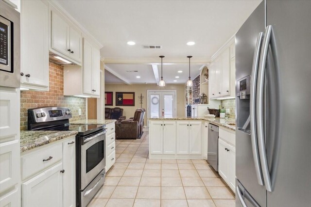 kitchen featuring appliances with stainless steel finishes, backsplash, light stone counters, and kitchen peninsula