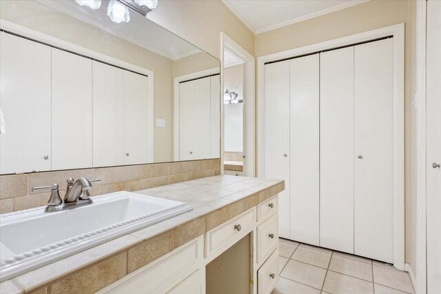 bathroom featuring tasteful backsplash, vanity, tile patterned floors, and ornamental molding