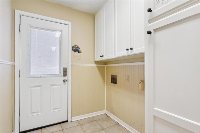 washroom with light tile patterned floors, cabinets, and washer hookup