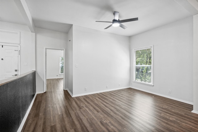 spare room featuring dark wood-type flooring and ceiling fan