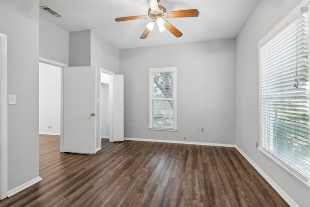 unfurnished bedroom featuring ceiling fan, wood-type flooring, and multiple windows