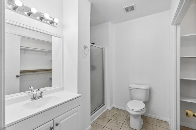 bathroom featuring tile patterned floors, walk in shower, vanity, and toilet