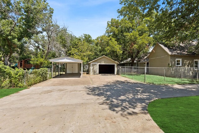 view of front facade with a garage, a front yard, and an outbuilding