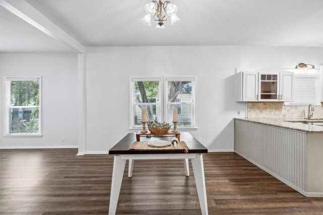 dining room with dark hardwood / wood-style flooring and a chandelier