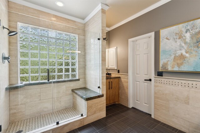 bathroom with tiled shower, plenty of natural light, and crown molding