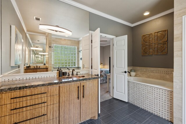 bathroom featuring tiled tub, crown molding, and vanity