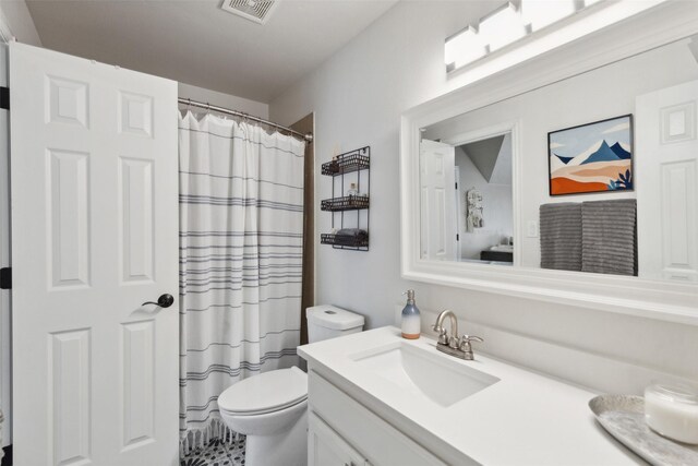 bathroom featuring a shower with shower curtain, toilet, and vanity