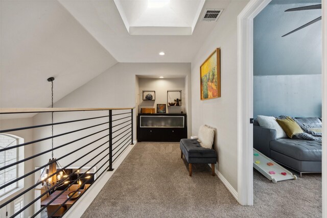 corridor featuring vaulted ceiling with skylight, a notable chandelier, and carpet floors