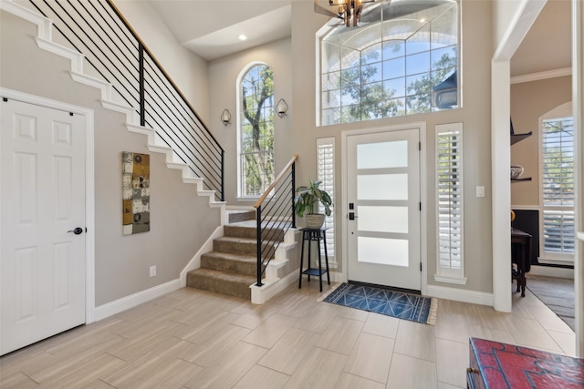 entryway featuring a high ceiling, a chandelier, and ornamental molding