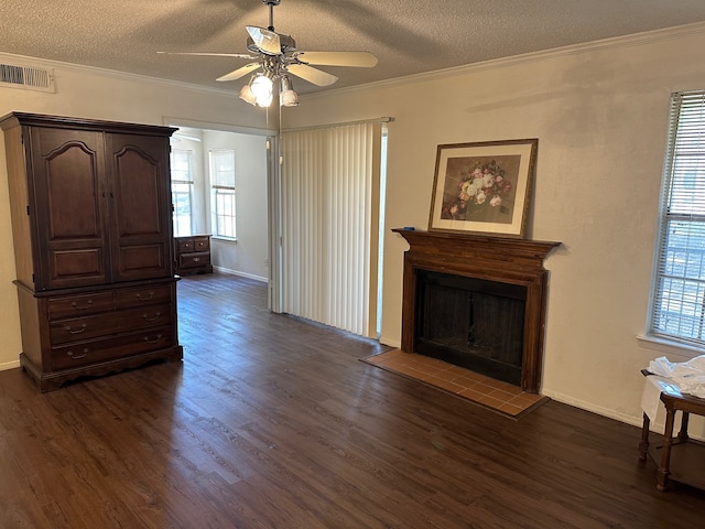 living room featuring ceiling fan, dark hardwood / wood-style flooring, a textured ceiling, and crown molding